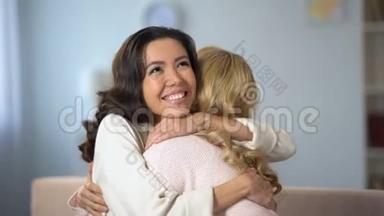 两位年轻女子拥抱在一起，真诚地微笑着，真诚的友谊，在室内